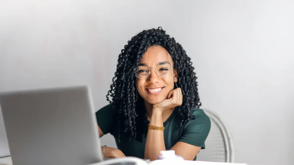 Smiling young girl while working on her laptop.